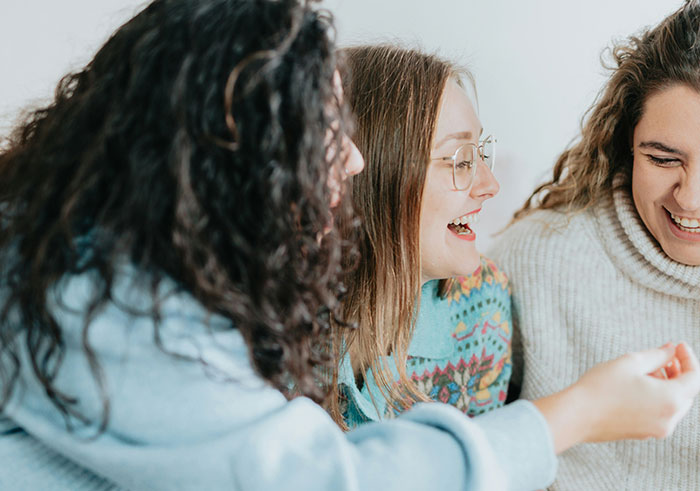 Three women sharing a lighthearted moment, contrasting typical funeral moments that became memorable for all the wrong reasons.