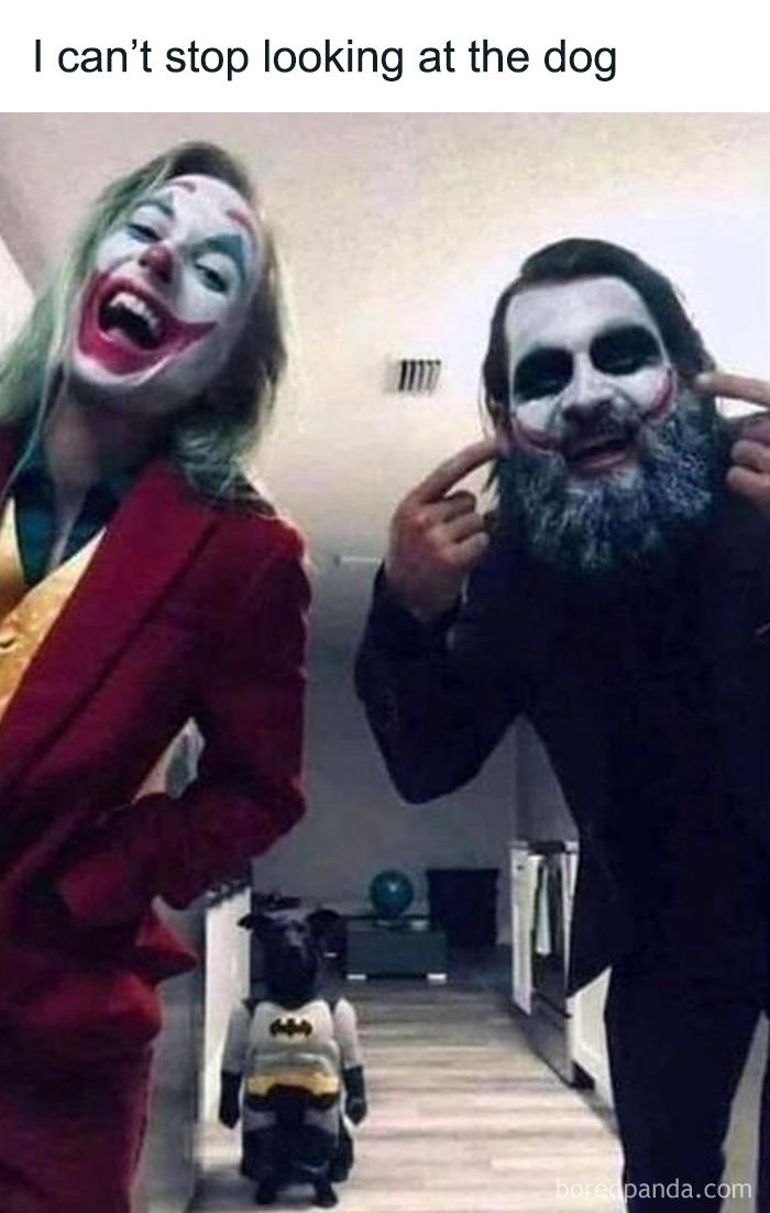 Two people in Joker makeup laughing while a dog dressed in a Batman costume stands in the background in a funny dog meme.