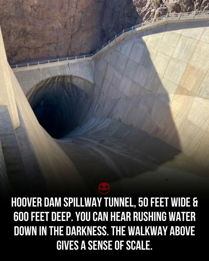 Hoover Dam spillway tunnel shown as a weird and odd fact with rushing water and walkway for scale.