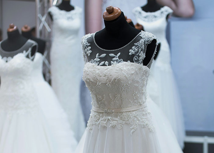 Elegant wedding dress on a mannequin with intricate lace details, highlighting bridal fashion and wedding dress trends.