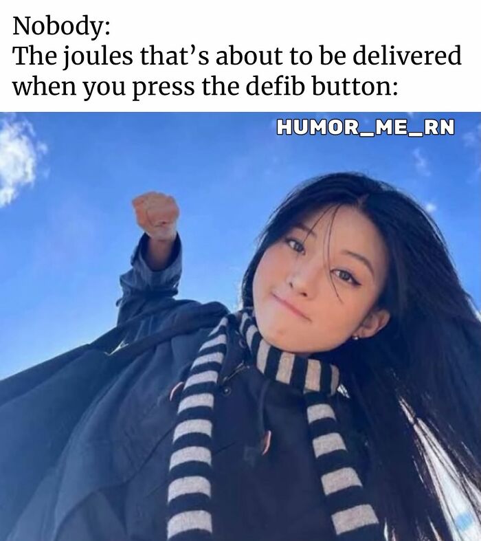 Woman in black coat and striped scarf with fist raised, humorously representing joules delivered by defibrillator button in healthcare memes.