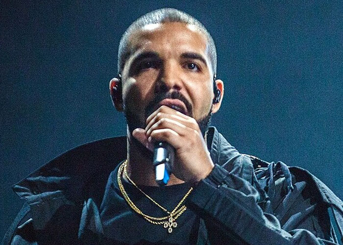 Male singer performing on stage wearing black jacket and gold chains, representing beloved celebrities not that nice in real life.