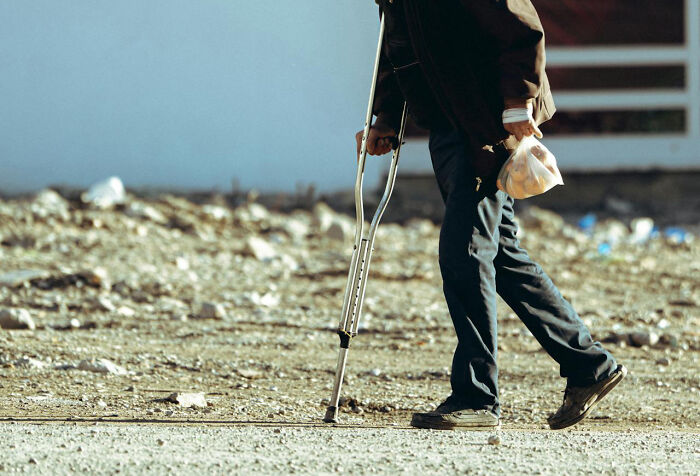 Person walking with crutches on rough terrain, highlighting hidden truths about hospitals that may scare patients.