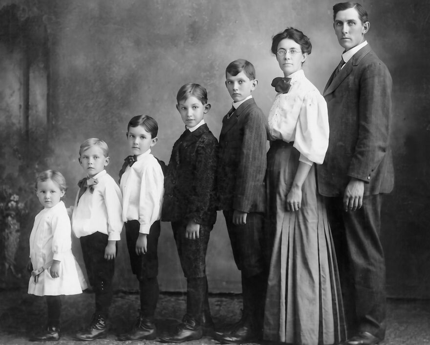 Vintage family portrait showing formal closeness and enmeshment trap in early 20th century with parents and six children in line.