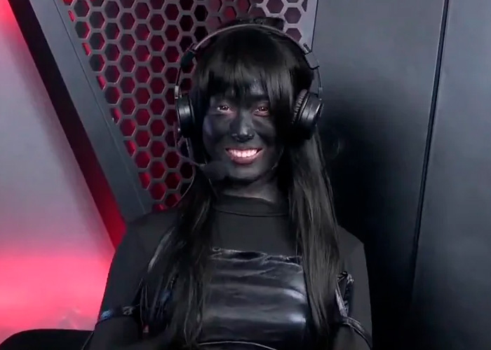 Esports host wearing headset and black outfit, smiling during a live broadcast with gaming studio background. Esports host wearing headset and black outfit, smiling during a live broadcast with gaming studio background.
