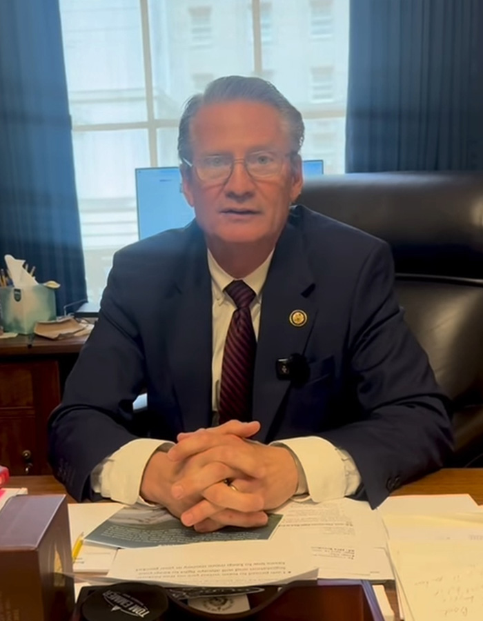 Man in a suit sitting at desk with paperwork, representing concern over missing or deceased scientists cases.