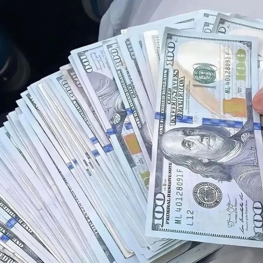 A hand holding a fanned stack of new 100 dollar bills. A clear image reflecting financial independence after financial a***e in marriage.