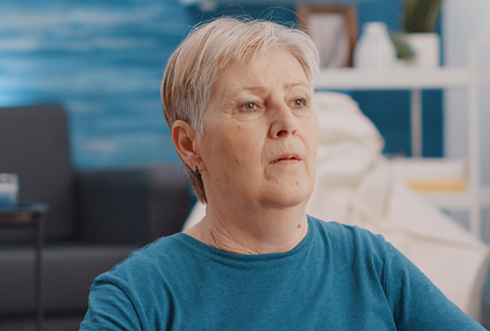Older woman with short gray hair and blue shirt looking concerned, reflecting mom&rsquo;s creepy behavior and psychotic doubts.