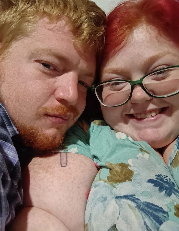 Close-up of a smiling woman with glasses and red hair beside a man with red hair, related to My 600-Lb. Life star Dolly Martinez.