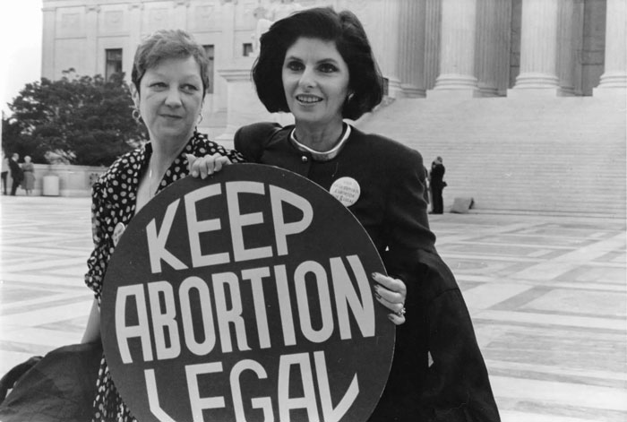 Two women holding a Keep Abortion Legal sign, representing a massive betrayal in human history still discussed today.