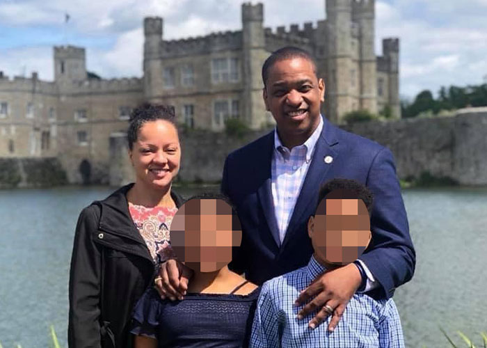 Ex-Virginia Lt. Governor Justin Fairfax with family outdoors near historic castle, highlighting chilling details in hole in her shirt case.