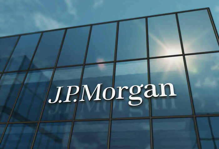 JPMorgan logo on a glass building facade reflecting the sky, representing companies and social media campaigns.