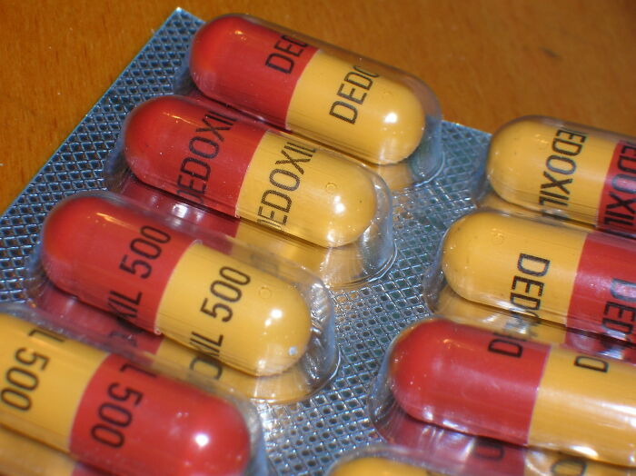 Close-up of red and yellow capsules in blister packs, illustrating health and care related to moms' stories.