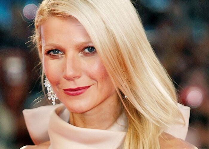 Blonde celebrity smiling at an event, showcasing iconic charm among beloved celebrities not that nice in real life.