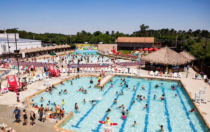 Crowded outdoor pool area with people swimming and relaxing, illustrating companies’ social media campaign missteps.