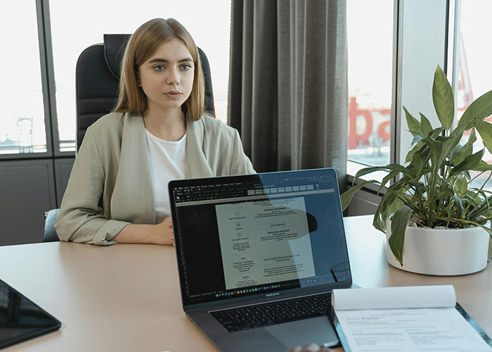 Young woman in an office setting discussing random signs indicating the economy is not doing well.