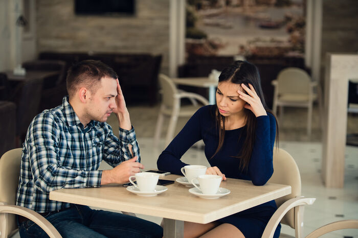 A couple having a tense first date in a cafe showing red flags and instant regret during conversation.