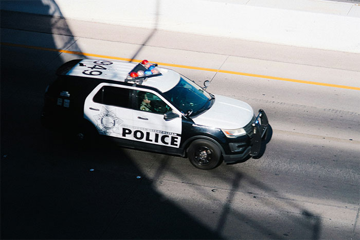 Police car driving on a city road, related to a woman sharing a crazy story about her mom like a soap opera.