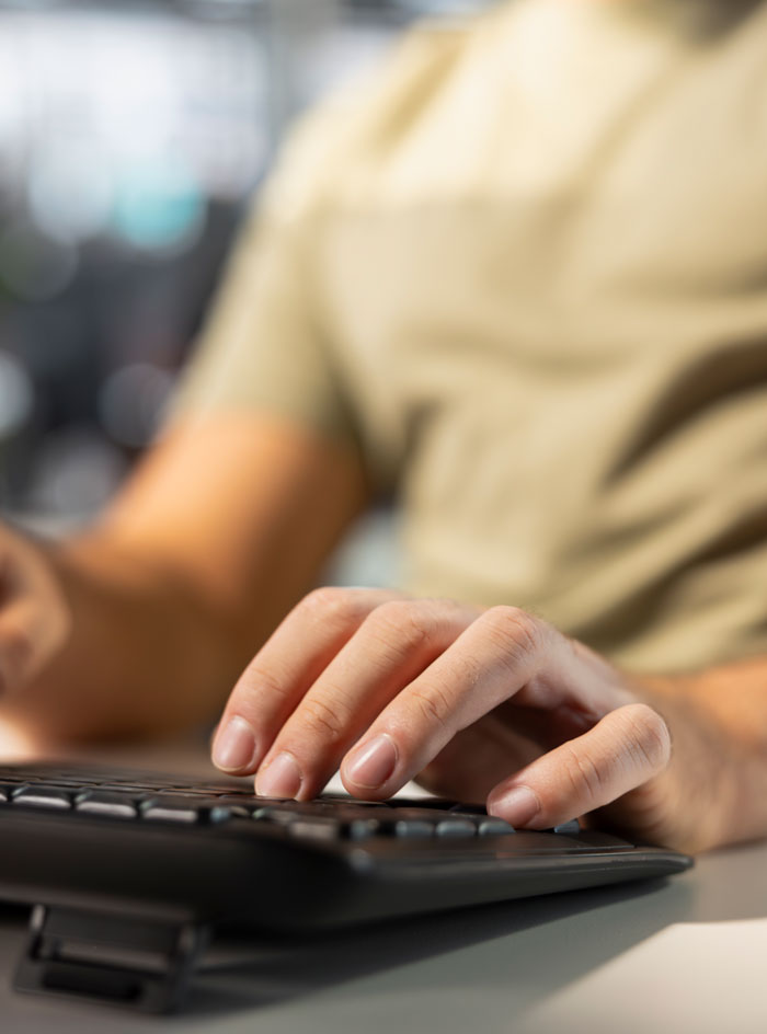 Person typing on keyboard at desk, representing petty karma served to bosses in satisfying manager stories.