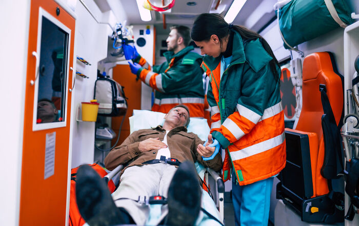 Medical workers treat a patient in an ambulance, often witnessing things they wish to unsee during their work.