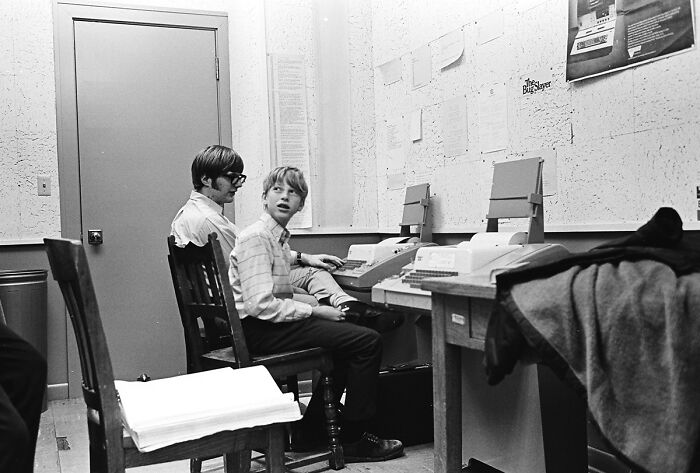 Two boys using vintage computers in a small office, illustrating technology from the year you were born timeline.