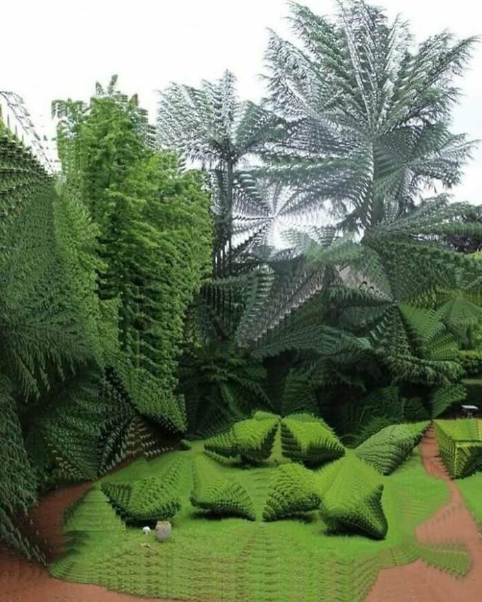 Distorted and confusing image of a garden with trees and bushes where things only get weirder the longer you look.