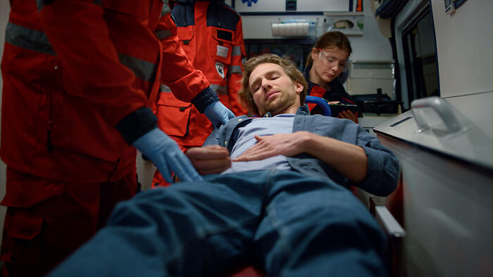 Medical workers attend to a patient on a stretcher in an ambulance. They witness many nasty and revolting things.