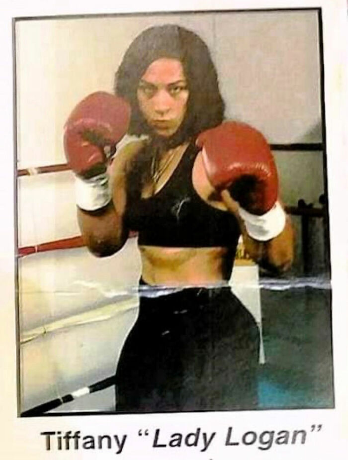 Woman boxer wearing red gloves in a fighting stance showing strength and resilience, linked to stories about moms.