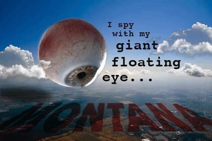 Surreal image of a giant floating eyeball with clouds over a landscape, showcasing confusing and unhinged visuals.