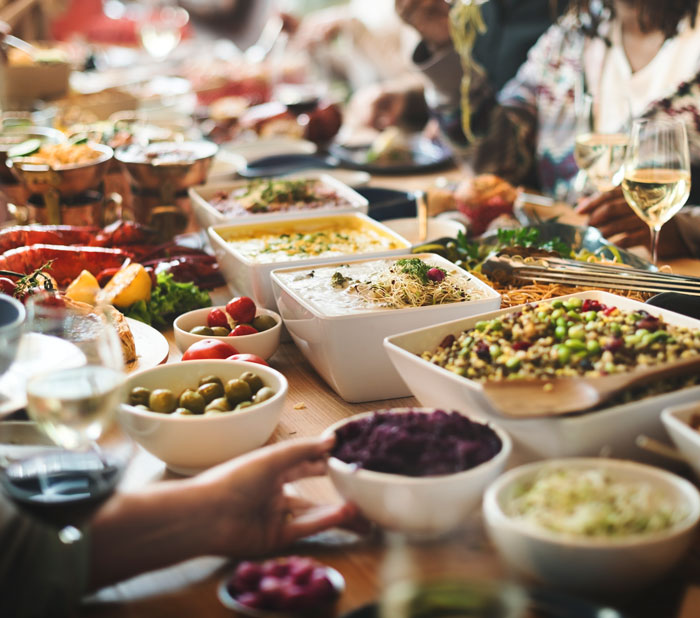 A vibrant buffet table laden with various dishes, including salads, olives, and appetizers. Avoid gross office stories.