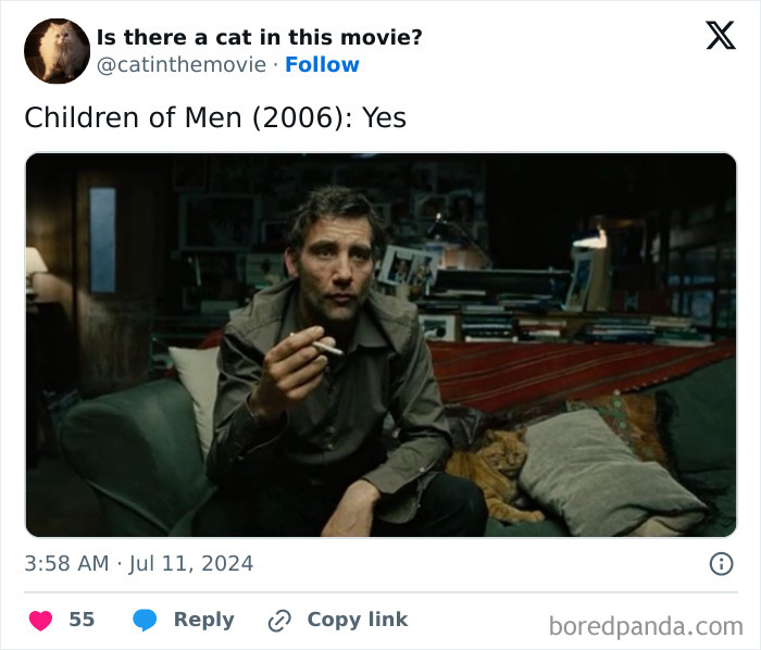 A screenshot from Children of Men (2006) showing Clive Owen smoking, with a ginger cat in cinema partially visible on the sofa.