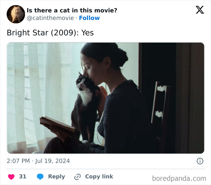 A woman kisses a black and white cat while reading a book in a still from the film Bright Star, showcasing a cat in cinema.