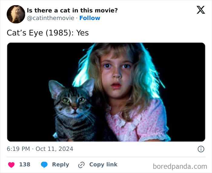 A young Drew Barrymore with wide eyes next to a tabby cat, featured in a list of cats in cinema.