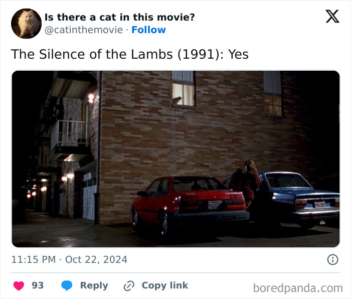 A white cat in cinema peeking out of a window in The Silence of the Lambs. Two cars and a person are parked below.