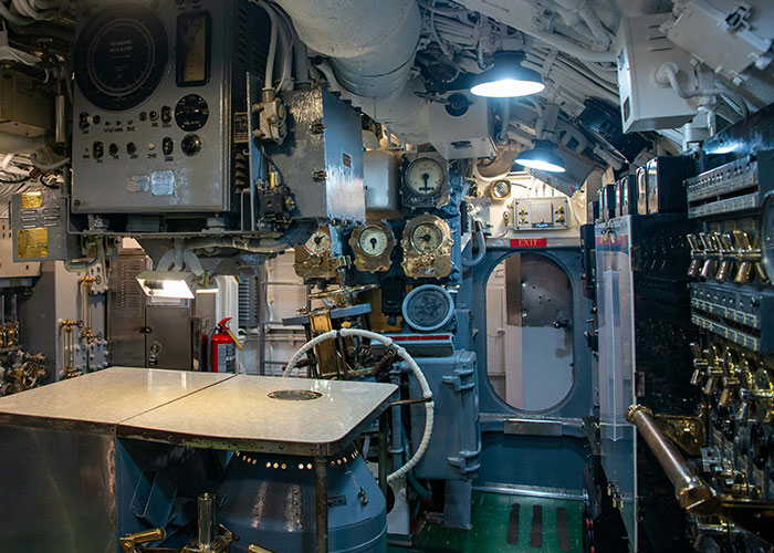 The intricate control room of a submarine, filled with gauges and levers, showing exclusive access to this amazing place.