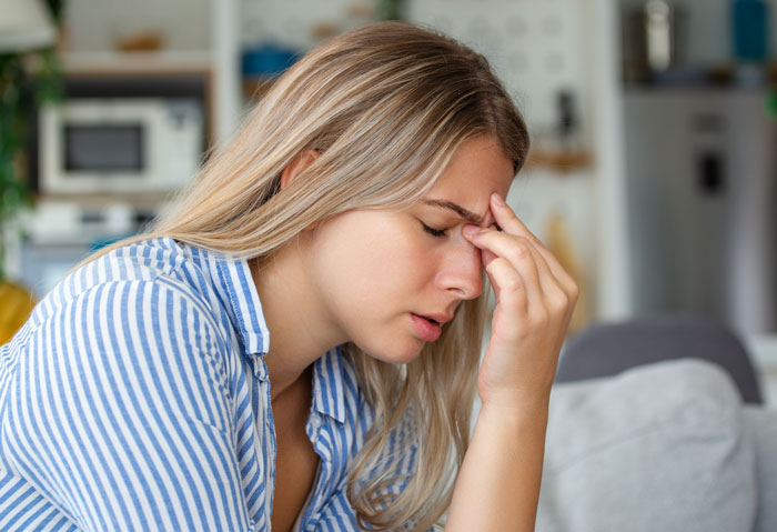 Mulher frustrada segurando a testa dentro de casa, transmitindo estresse sobre um marido delirante pedindo à esposa para criar um filho. Mulher frustrada segurando a testa dentro de casa, transmitindo estresse sobre um marido delirante pedindo à esposa para criar um filho.