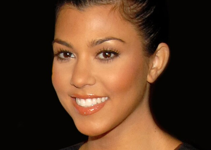 Close-up portrait of a smiling celebrity with sleek hair against a black background, highlighting beloved celebrities not nice in real life