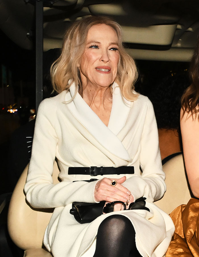 Catherine O’Hara wearing white coat and black belt, seated indoors, related to brother sharing shocking detail before passing Catherine O’Hara wearing white coat and black belt, seated indoors, related to brother sharing shocking detail before passing