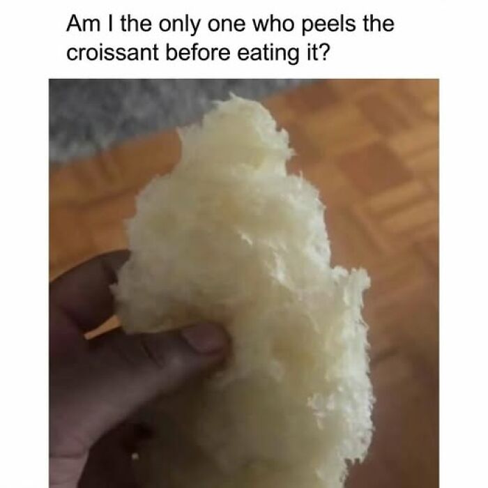 Hand holding the peeled fluffy inside of a croissant, showcasing a funny food meme for quick chuckles.