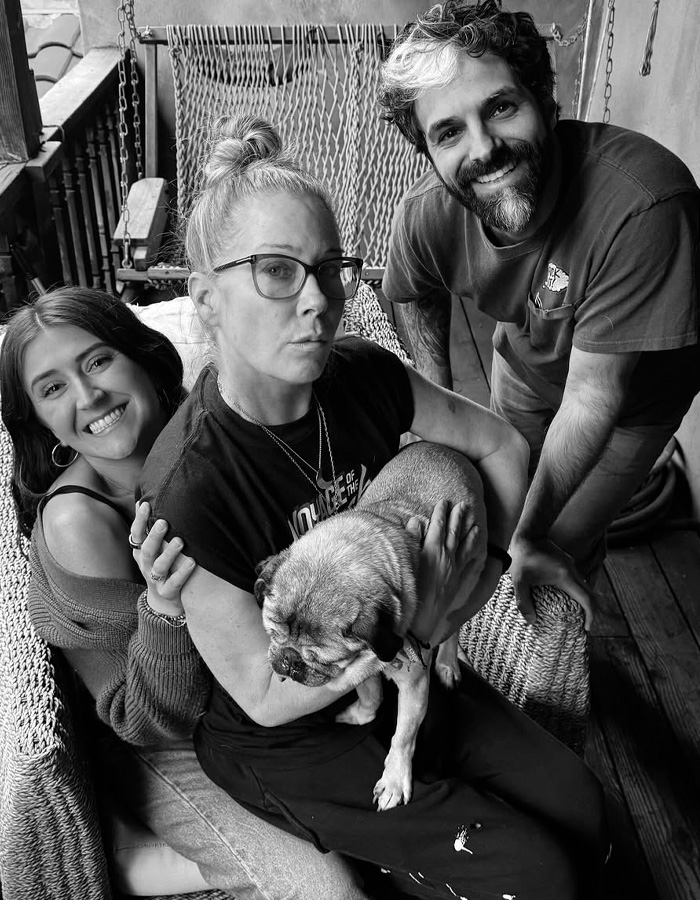 Christina Applegate with loved ones and dog on porch, showing support amid hospitalization concerns and hellish health details revealed.