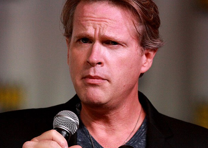 Middle-aged man holding a microphone with a serious expression, illustrating beloved celebrities not that nice in real life.