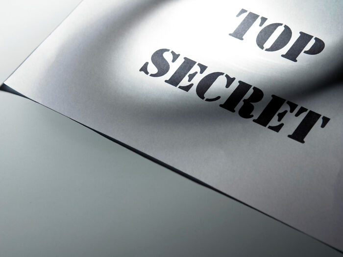 A document marked "TOP SECRET" with a spotlight effect, symbolizing celebrity relatives secrets and untold stories.