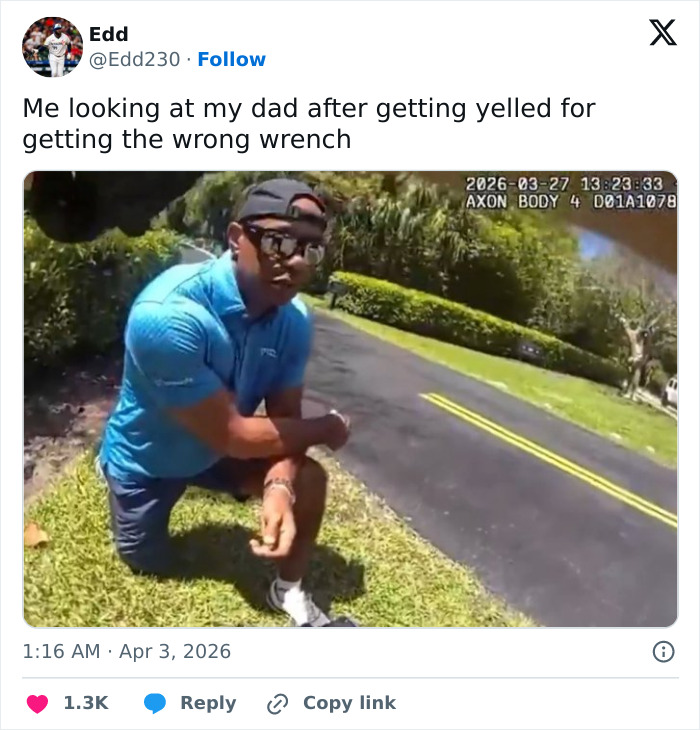 Man wearing a blue shirt and cap kneeling on grass by roadside with timestamp from police body camera footage.