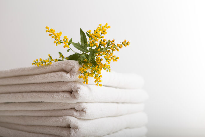 Stack of white towels with a small bouquet of yellow flowers, illustrating unusual items TSA has had to confiscate.