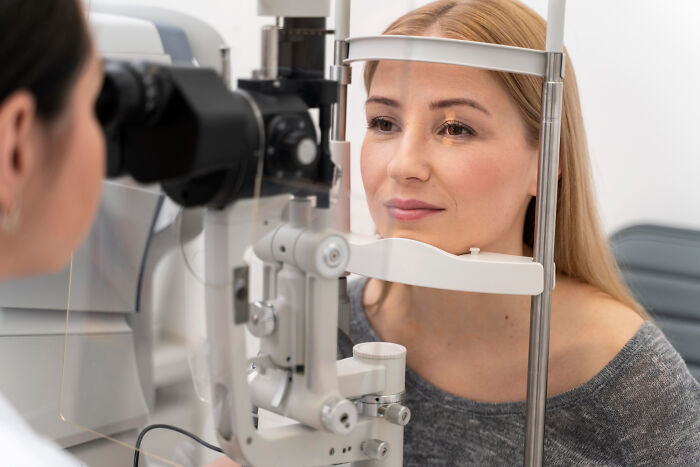 Woman undergoing an eye exam at a clinic discovering random facts about their body during a medical checkup.