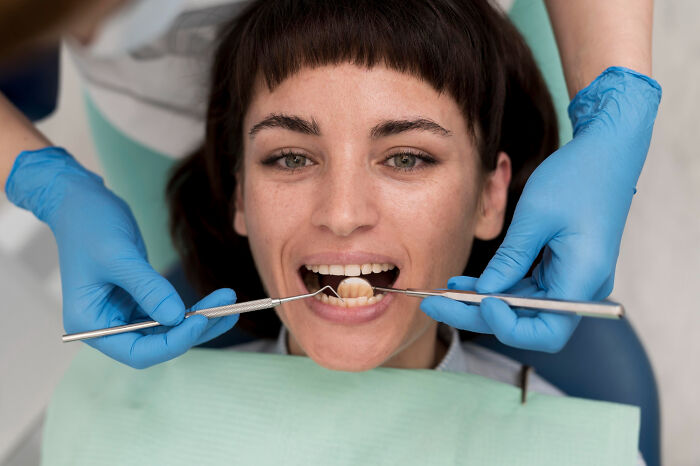 A woman with an open mouth at the dentist, having her teeth examined. Could this be one of the disturbing sounds?