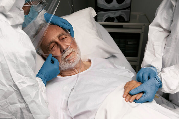 Healthcare professionals assist an elderly patient in a hospital bed, evoking feelings from disturbing sounds.