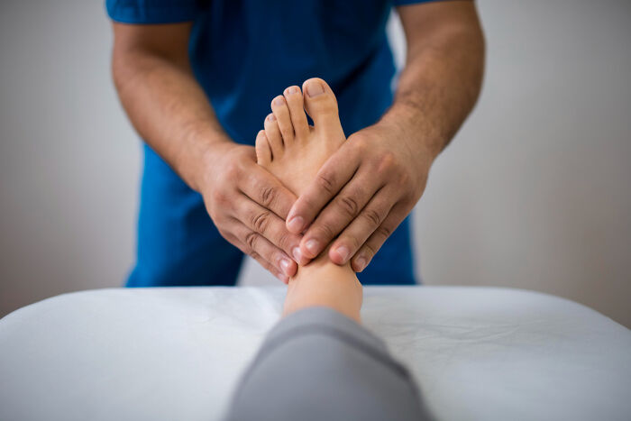Doctor examining patient's foot during a medical checkup, revealing random facts about the human body.