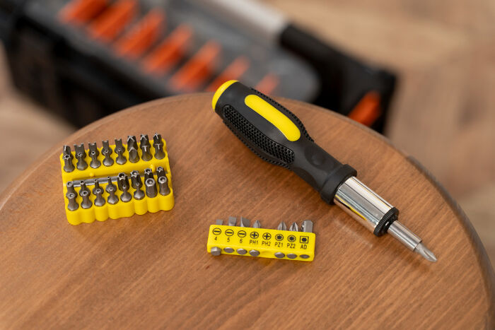 A set of screwdriver bits and a handle placed on a wooden surface, an example of TSA confiscated items.