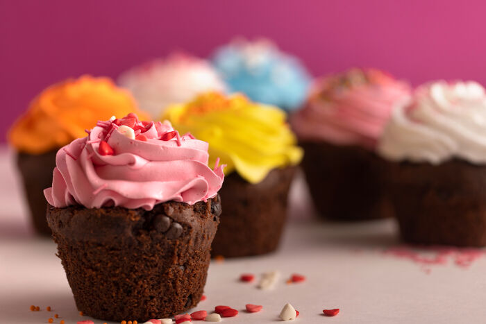 Chocolate cupcakes with colorful frosting arranged on a table symbolizing times being a good person led to betrayal.